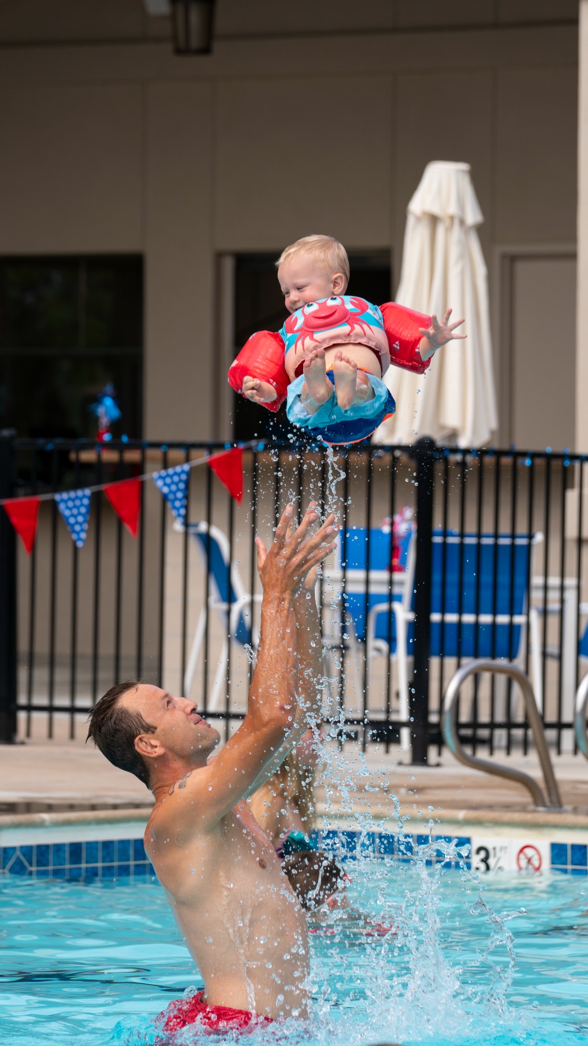 Joseph Selander joyfully tossing his young son above the swimming pool